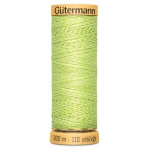 A spool of Gütermann thread in light green. The spool is labeled with "Gütermann" on the top and "100 m - 110 yds" on the bottom. The thread is neatly wound, highlighting its smooth texture.