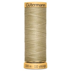 A spool of Gütermann thread. The thread is a light beige color and the spool is labeled with "Gütermann" at the top and "100 m - 110 yds" at the bottom. The thread is neatly wound around the spool.