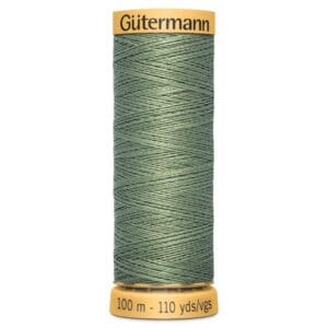 A spool of Gütermann thread in a muted green color. The spool is labeled with the brand name at the top and indicates it contains 100 meters or 110 yards of thread. The texture and tight winding of the thread are visible.