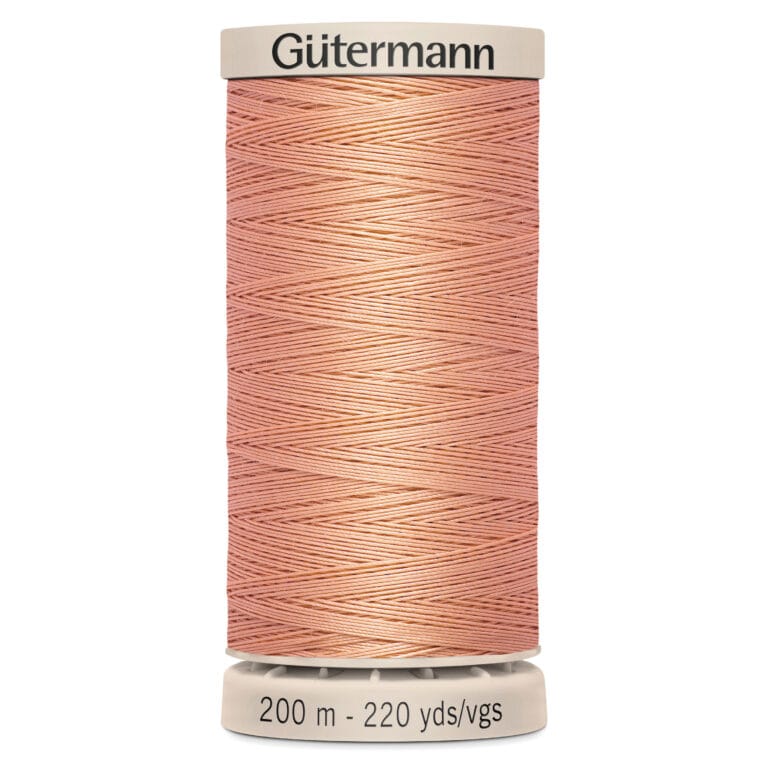 A spool of Gütermann thread in coral pink, labeled with "200 m - 220 yds/vgs" at the base. The thread is wound neatly around the spool.