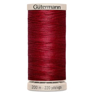 A spool of Gütermann red sewing thread marked as 200 meters or 220 yards. The spool has a beige top and bottom, with the brand name printed on the top.
