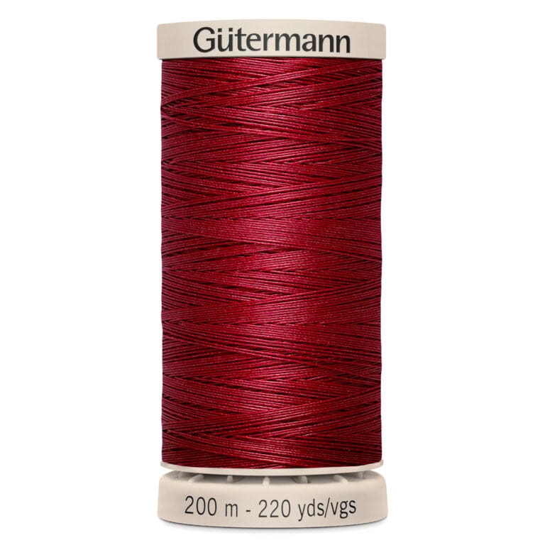 A spool of Gütermann red sewing thread marked as 200 meters or 220 yards. The spool has a beige top and bottom, with the brand name printed on the top.