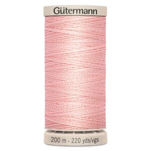 A spool of Gütermann thread in light pink with white stripes. The spool displays "200 m - 220 yds/vgs" on the base.
