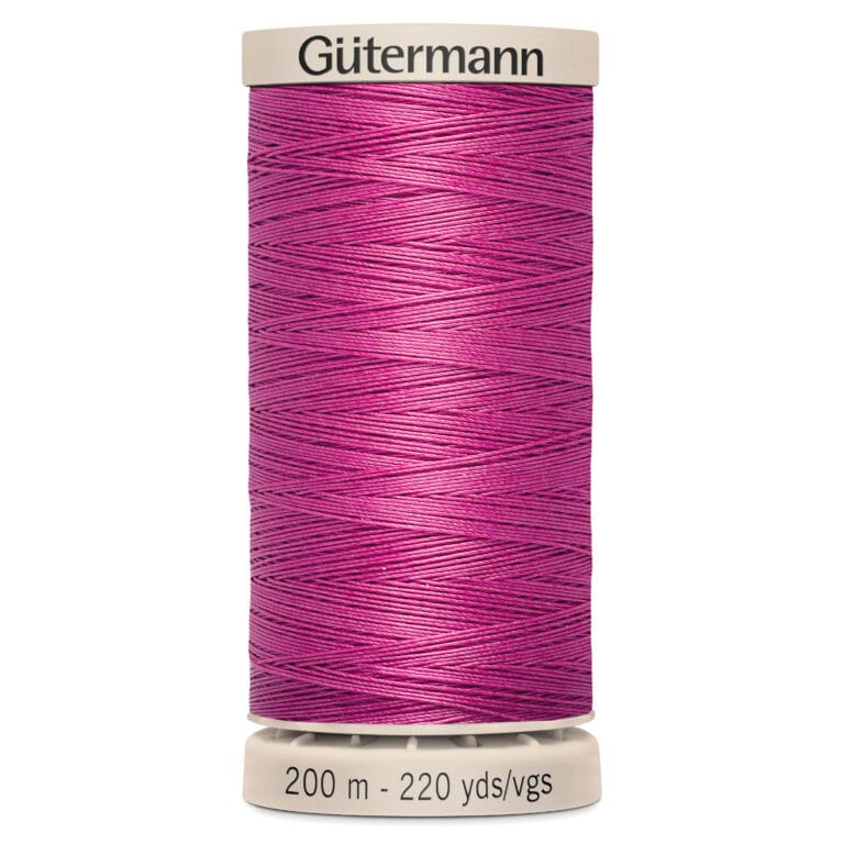 A spool of Gütermann thread in vibrant magenta. The spool features white caps on the top and bottom, with labeling indicating the thread length as 200 meters or 220 yards.