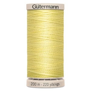 A spool of Gütermann sewing thread in light yellow, labeled with "200 m - 220 yds/vgs." The spool has a beige top and bottom with the brand name at the top. The thread is neatly wound around the spool.