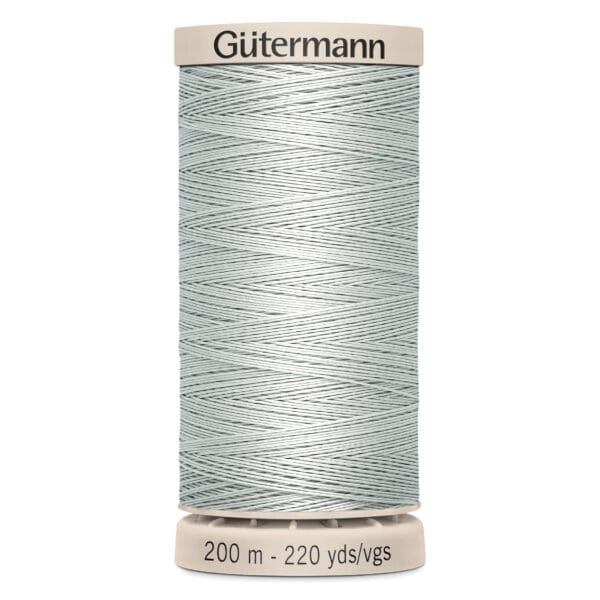 A spool of Gütermann thread in light gray. The spool is vertical, displaying the brand name on top. The label indicates it contains 200 meters or 220 yards of thread. The thread is evenly wound around the spool.