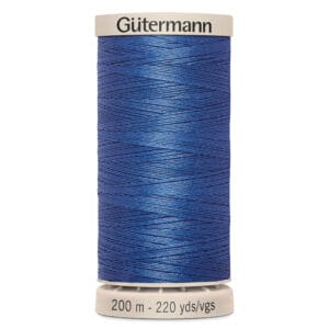 A spool of Gütermann thread stands upright. It is vibrant blue, with the label indicating it contains 200 meters (220 yards) of thread. The brand name is printed in black on the top edge of the spool.