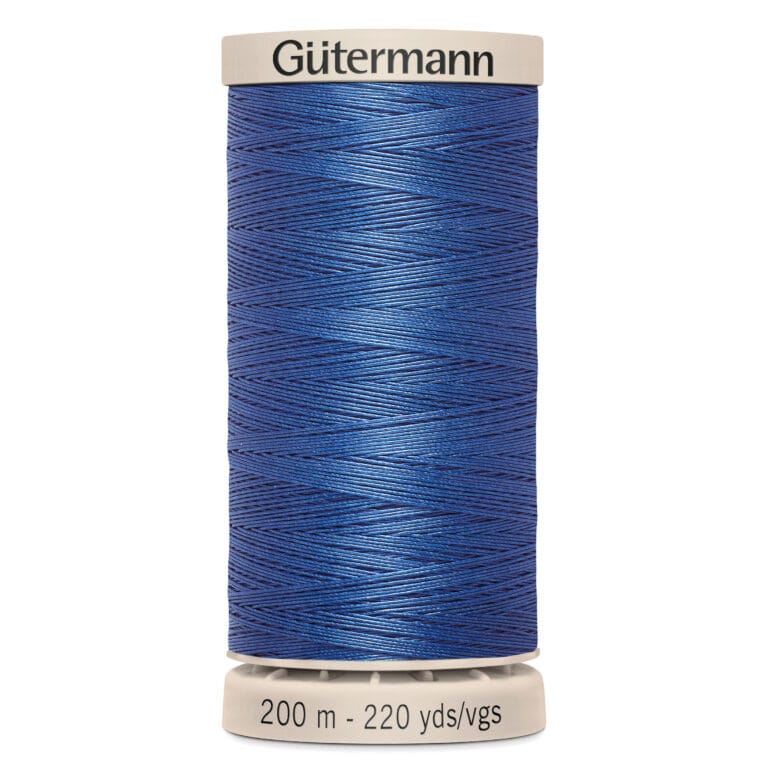 A spool of Gütermann thread stands upright. It is vibrant blue, with the label indicating it contains 200 meters (220 yards) of thread. The brand name is printed in black on the top edge of the spool.