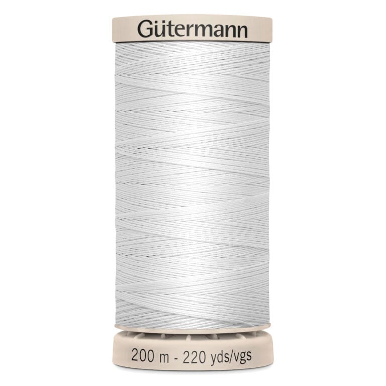 A spool of Gütermann white sewing thread, labeled with "200 m - 220 yds/vgs," stands vertically. The spool has a beige top and bottom with the brand name "Gütermann" printed on the top.