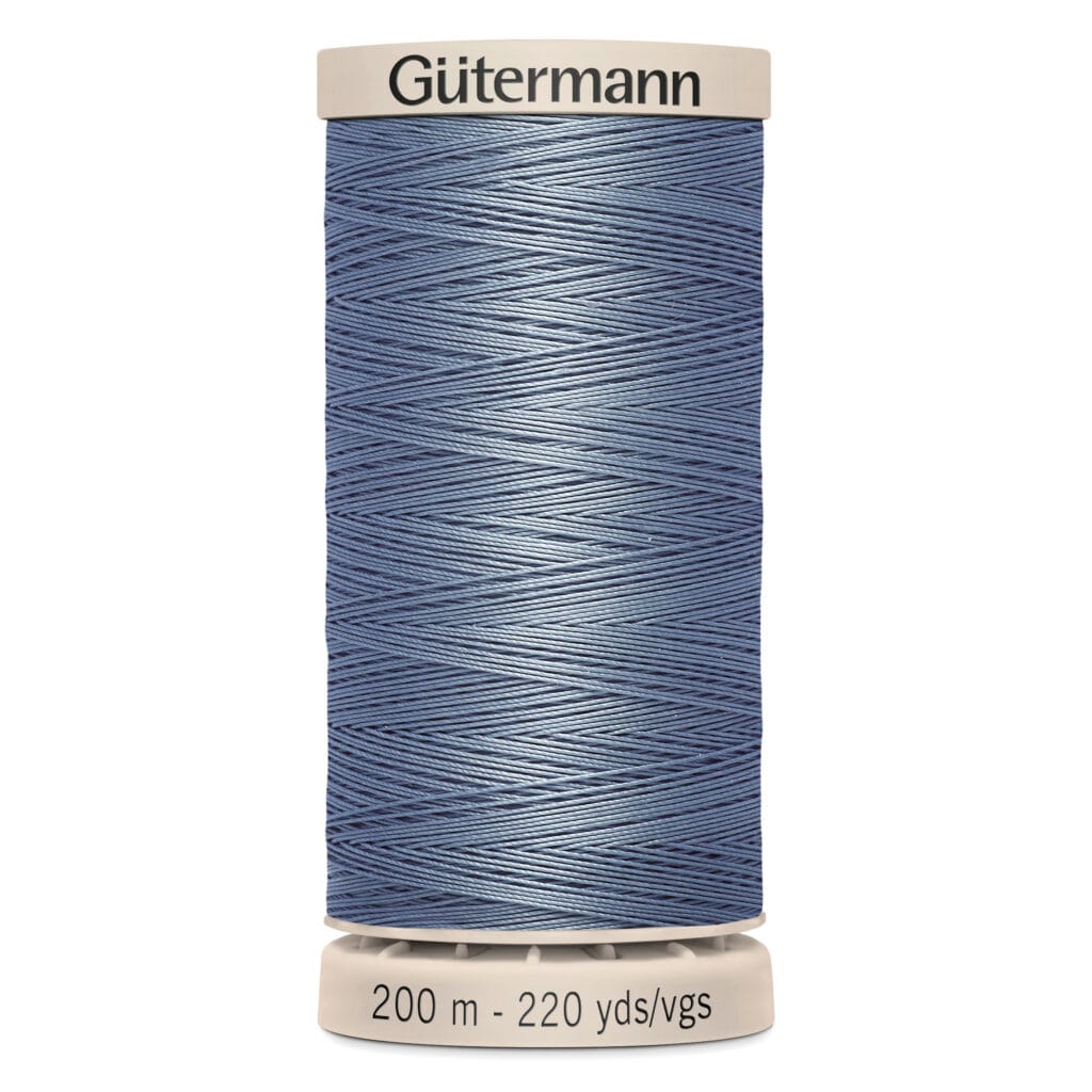 A spool of Gütermann thread in a shade of blue, wrapped neatly around the spool. The text at the base reads "200 m - 220 yds/vgs.