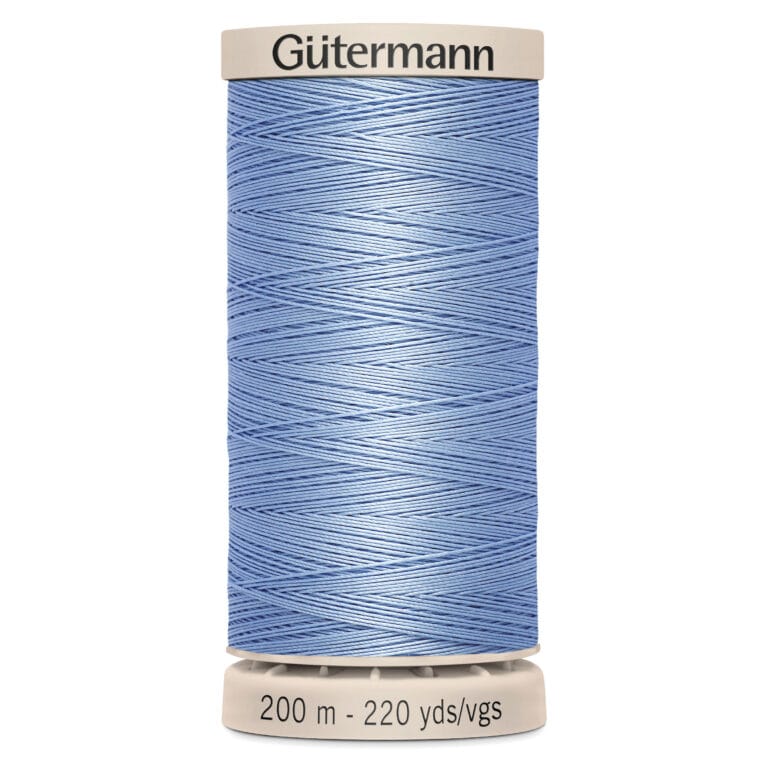 A spool of blue Gütermann thread is shown vertically, wrapped neatly around a beige base. The label reads "200 m - 220 yds/vgs.