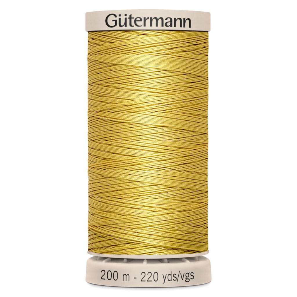 A spool of Gütermann polyester thread in a golden yellow color, with a label indicating it's 200 meters and 220 yards long. The spool is vertically positioned, with a beige base and top.