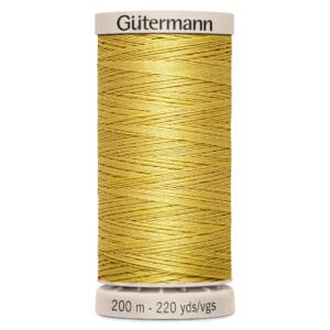 A spool of Gütermann polyester thread in a golden yellow color, with a label indicating it's 200 meters and 220 yards long. The spool is vertically positioned, with a beige base and top.