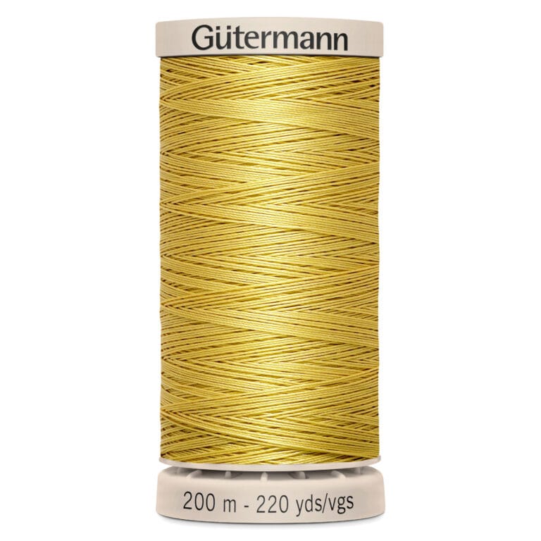 A spool of Gütermann polyester thread in a golden yellow color, with a label indicating it's 200 meters and 220 yards long. The spool is vertically positioned, with a beige base and top.