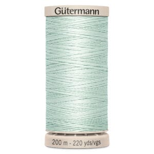 A spool of Gütermann sewing thread, pale green in color, wrapped neatly around the spool. The top and bottom of the spool are beige, labeled with "Gütermann" and "200 m - 220 yds/vgs.
