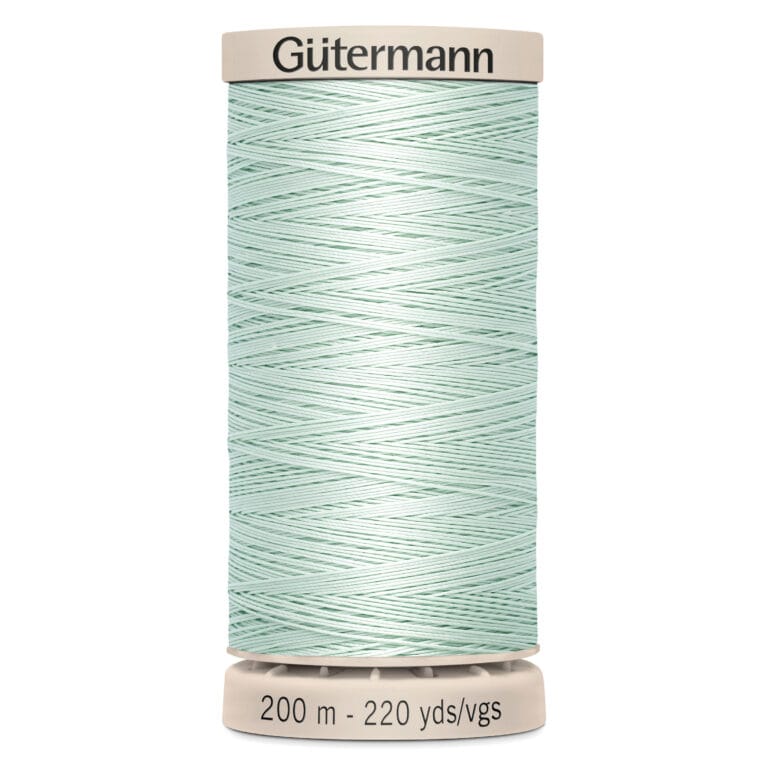 A spool of Gütermann sewing thread, pale green in color, wrapped neatly around the spool. The top and bottom of the spool are beige, labeled with "Gütermann" and "200 m - 220 yds/vgs.