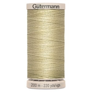 A spool of Gütermann thread in a light beige color. The label at the top displays the brand name, and the bottom indicates the length as 200 meters or 220 yards. The thread is neatly wound on a cylinder.