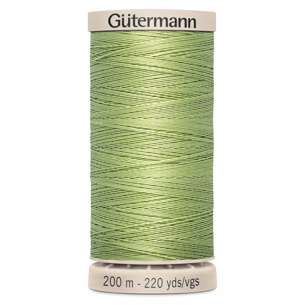 A spool of Gütermann sewing thread in a light green color. The label indicates it is 200 meters or 220 yards in length. The spool and label are cream-colored.