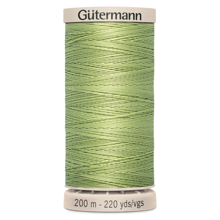 A spool of Gütermann sewing thread in a light green color. The label indicates it is 200 meters or 220 yards in length. The spool and label are cream-colored.