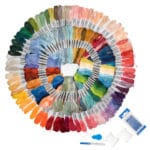 A spiral arrangement of colorful embroidery floss in various shades, ranging from greens and blues to reds and yellows. Accompanying the thread are embroidery tools including needles, a needle threader, and organizers.