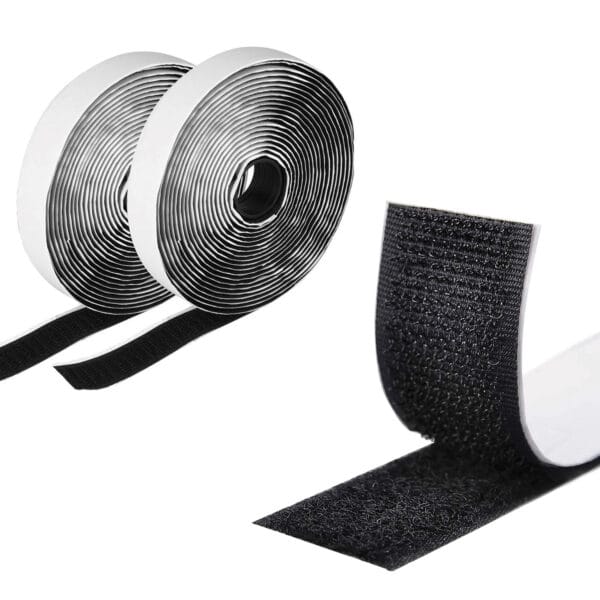 Two rolls of black adhesive hook and loop fastener tape are unrolled, revealing one side with hooks and the other with loops. The tape appears glossy, with each roll neatly coiled, and the cut section shows the fastening mechanism.