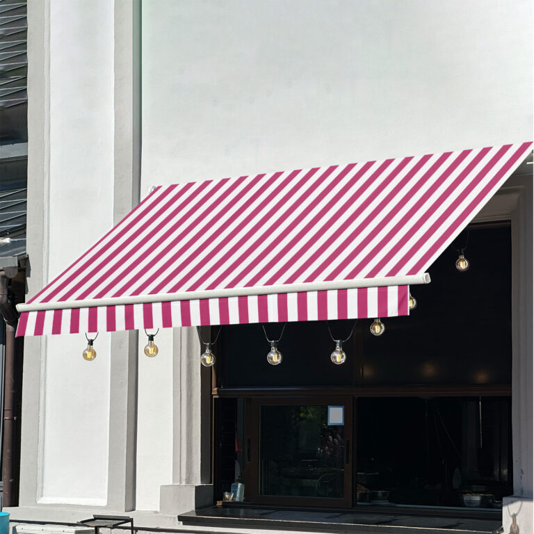 A pink and white striped awning extends over a window with hanging string lights, attached to a white building with dark window trim.