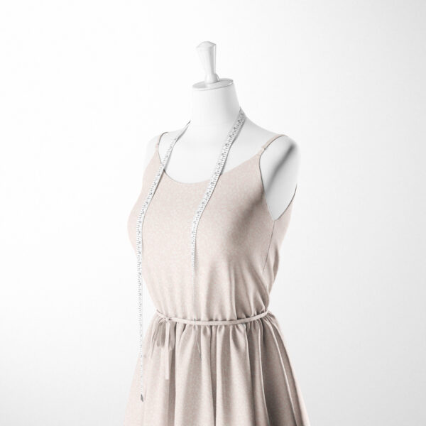 A white dress form mannequin wearing a light pink sleeveless dress with a cinched waist, draped with a white measuring tape around the neck, set against a plain white background.