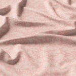 A piece of light pink fabric with a subtle floral pattern and soft, natural folds and creases.