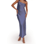 A person wearing a silky, one-shoulder, floor-length purple dress and clear-heeled sandals stands against a plain white background.