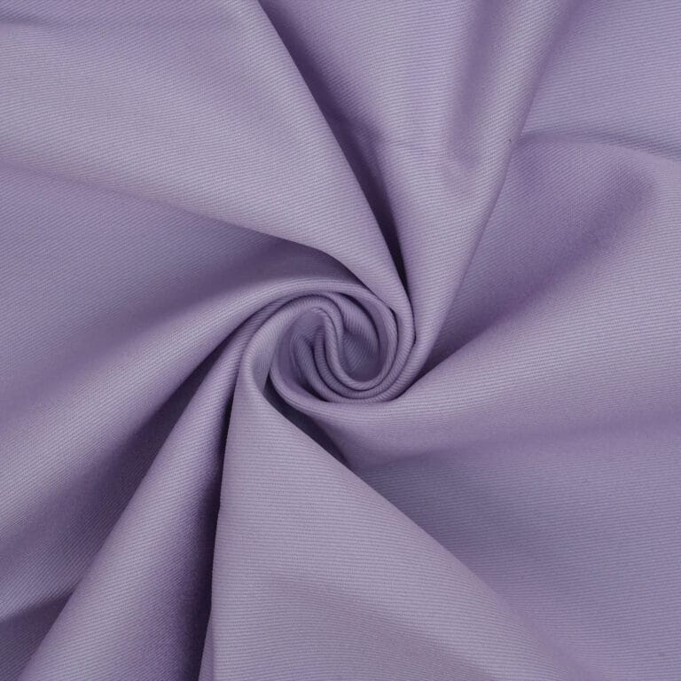A close-up of light purple fabric twisted into a spiral, showing a smooth texture and soft folds radiating from the center.