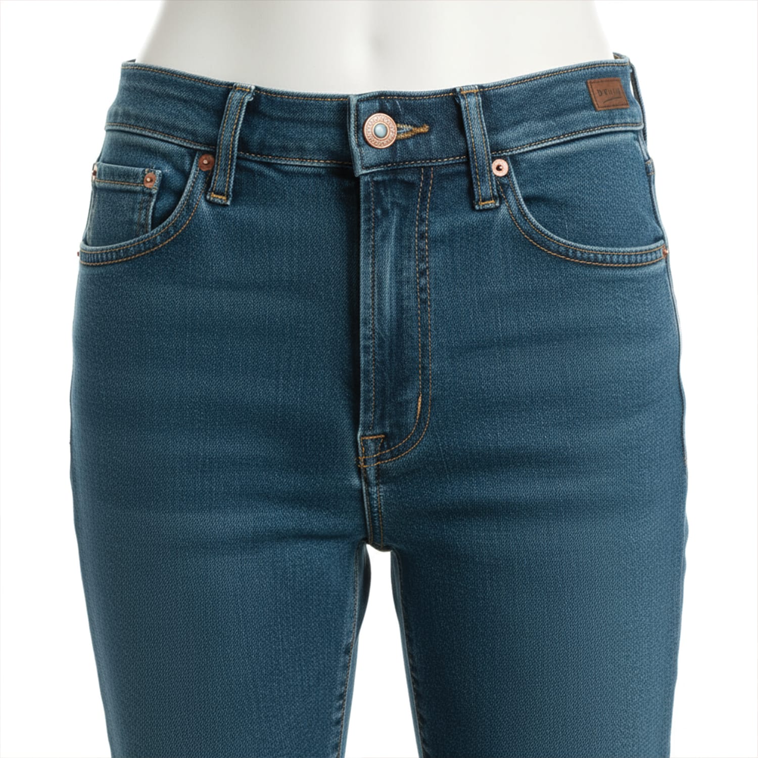 Jeans-Denim-Indigo-Petrol-6 A close-up view of a person wearing blue denim jeans with copper rivets and a button closure, showing the front waist and upper thighs. The jeans have front pockets and visible stitching.