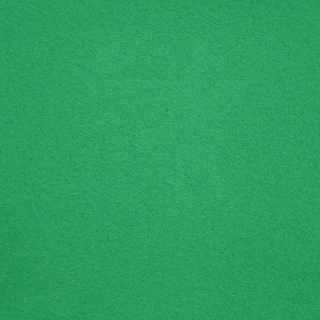 A close-up view of a green felt surface, showing its soft, textured fabric. The color is solid and even throughout the image.