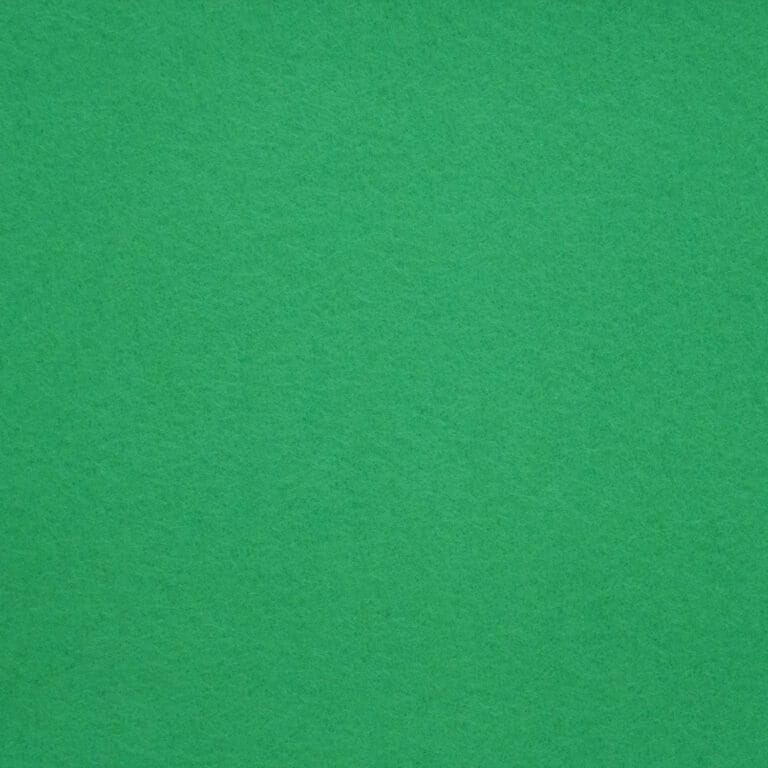 A close-up view of a green felt surface, showing its soft, textured fabric. The color is solid and even throughout the image.
