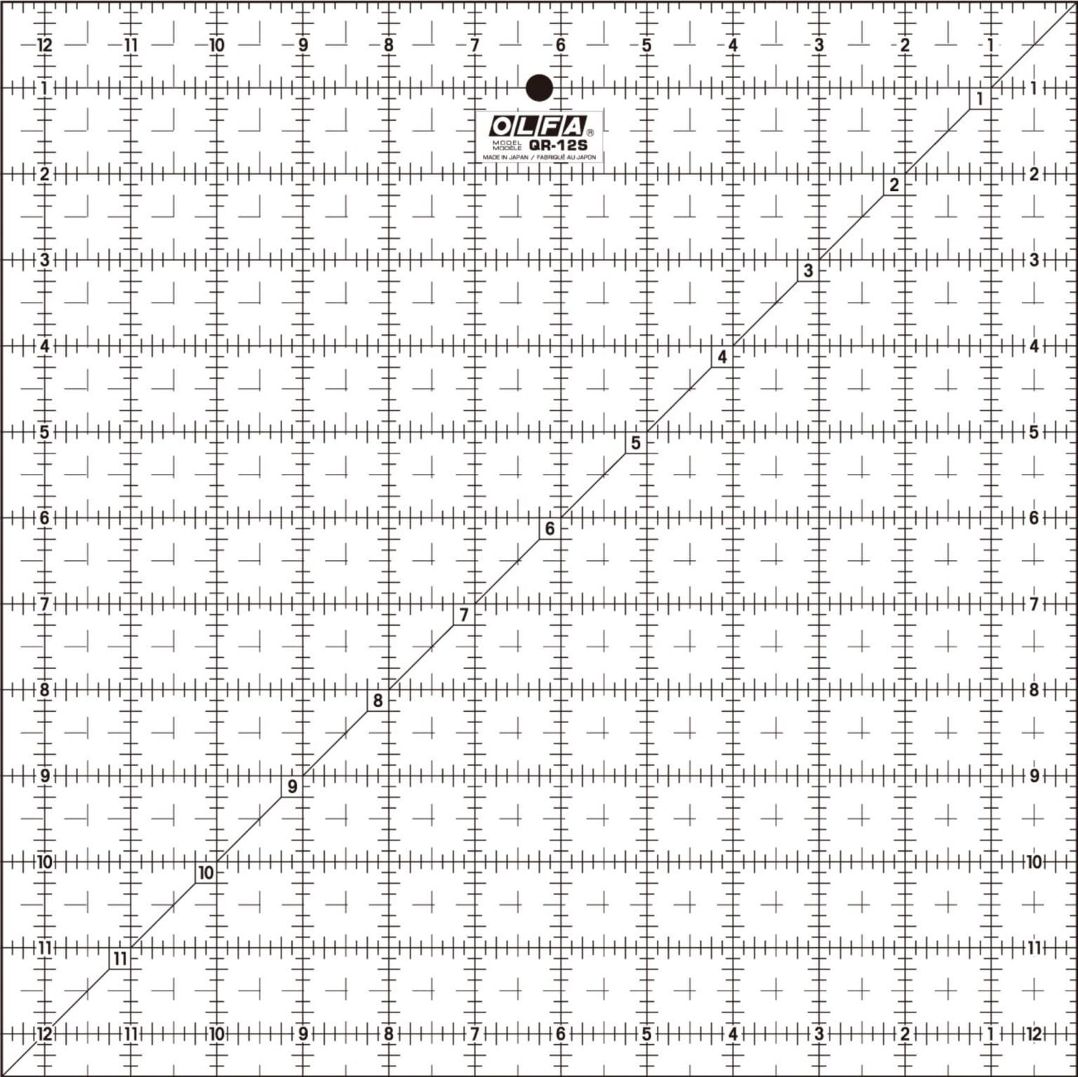 A clear OLFA QR-12S quilting ruler with black grid lines, numbers, and a diagonal line from corner to corner, marked in inches up to 12 by 12, used for measuring and cutting fabric.