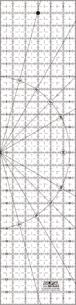 A transparent quilting ruler with black grid lines, numerical measurements, diagonal angles, and circles marked for precise cutting, labeled "dritz omnigrid" at the bottom.