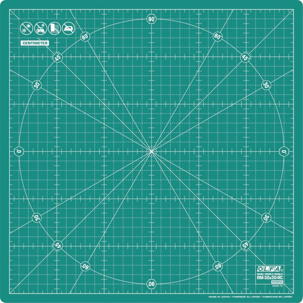 Green cutting mat with a grid, diagonal lines, a large circle, and angle markings. Icons at the top indicate usage. "OLFA" branding and "RM-30x30" model info are in the bottom right corner. Measurements are in centimeters.