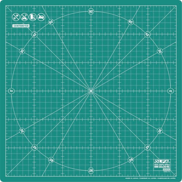 Green cutting mat with a grid, diagonal lines, a large circle, and angle markings. Icons at the top indicate usage. "OLFA" branding and "RM-30x30" model info are in the bottom right corner. Measurements are in centimeters.
