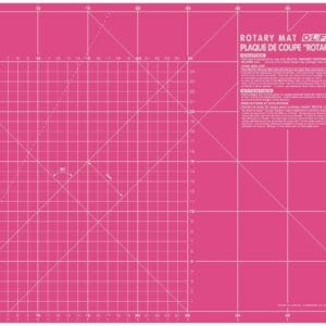 A large pink self-healing rotary cutting mat marked with a white centimeter grid, diagonal lines, angles, and measurement numbers, with product information in the top right corner.