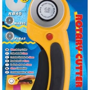 A yellow and black OLFA rotary cutter in its packaging, labeled "RTY-2/DX" for 45mm blades. The package highlights features and compatible blade types, with text in English, French, and Spanish.