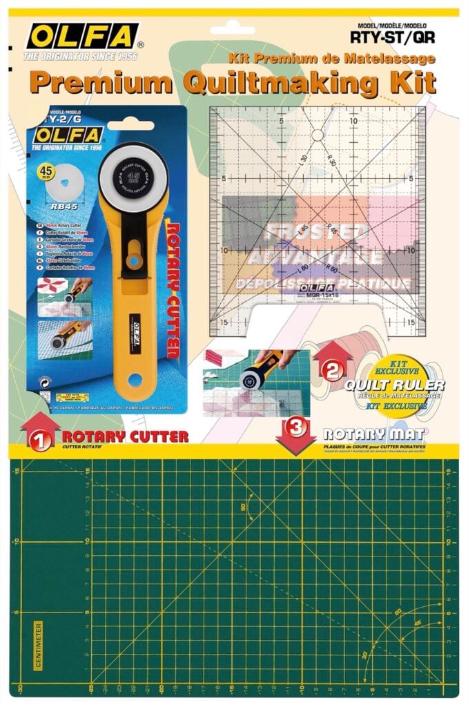 OLFA Premium Quiltmaking Kit packaging showing a rotary cutter, a clear grid quilt ruler, and a green cutting mat with yellow grid lines, designed for quilting and fabric cutting.
