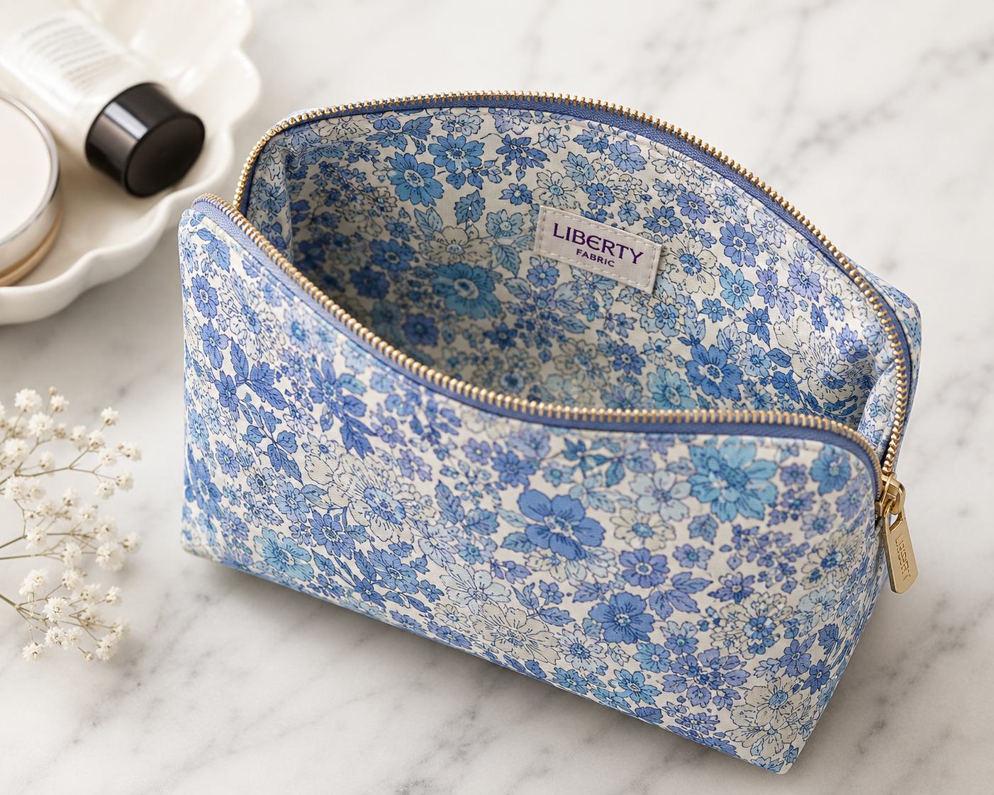 Liberty print lined zip makeup bag on marble surface, open to show cotton lining