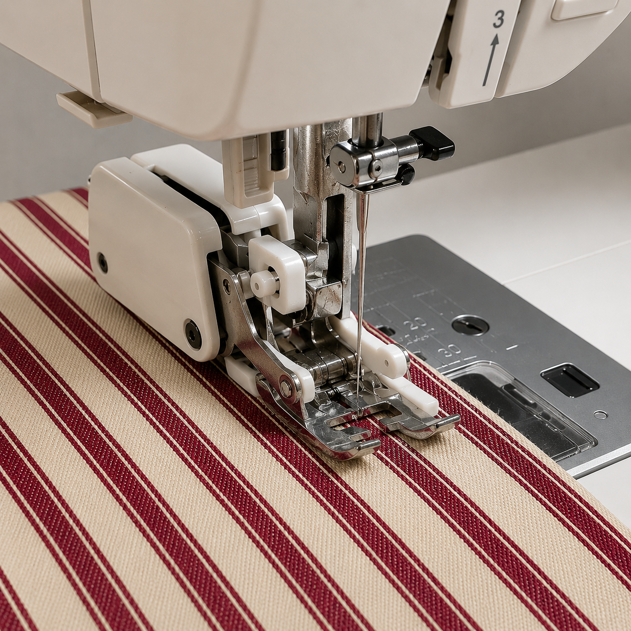 Walking foot presser foot attached to a domestic sewing machine feeding canvas ticking stripe fabric